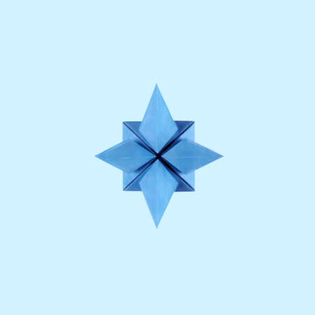 Origami blue paper rose of the winds on blue backgroundの写真素材