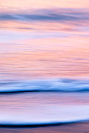 abstract landscape of sea. texture water, sky and sand in blurry motion in tropical sunset colorsの写真素材