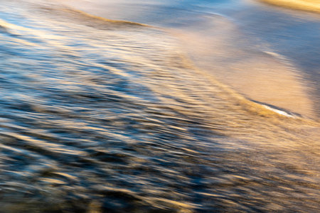 abstract landscape of sea. texture water and sand in blurry motion in the golden hourの写真素材