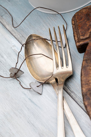 Vintage metal spot and fork on wooden tableの写真素材