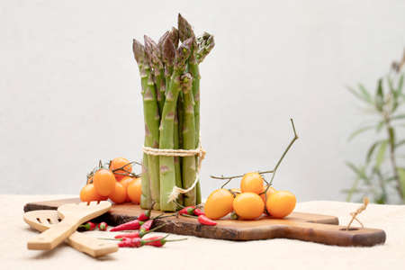 Fresh vegetables on a table. Composition with pumpkin, asparagus, orange tomatoes, chili Peppers.の写真素材