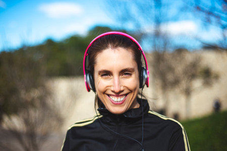 Portrait of a sporty young woman with headphones while exercising outdoors.