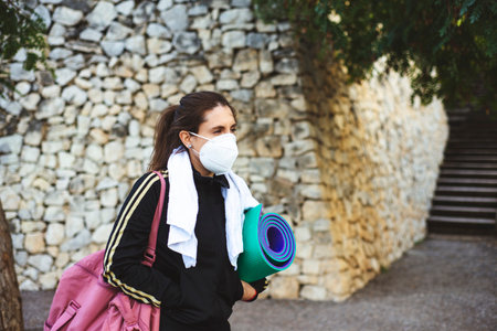 Female in the park wearing a white facemask - new normal amidst COVID19 pandemic