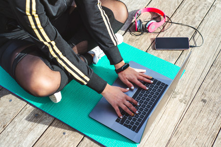 Fitness lifestyle. Girl is watching at a laptop video fitness lesson. Top viewの写真素材
