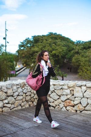 Fitness lifestyle. Girl walking with sport bag after the fitness lesson.の写真素材