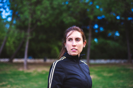 Outdoor portrait of serious girl about 30 years old at park, close-up.の写真素材