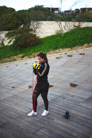 Young woman training with rubber bands to practice exercise. Sport Concept.の写真素材
