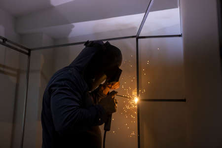 Worker welding a dressing room in a home renovation
