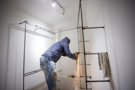 Colombian metal carpenter polishing metal in a dressing roomの写真素材