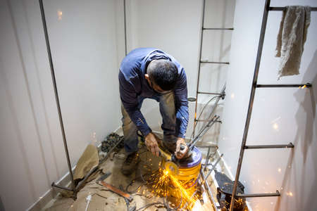 Colombian metal carpenter polishing metal in a dressing room