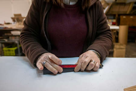Closeup shot of a Spanish woman working at a hand fan design workshopの写真素材