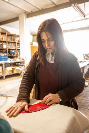 Vertical shot of a Spanish woman working at a hand fan design workshopの写真素材