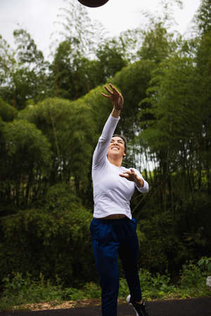 Vertical shot of a Hispanic woman with blonde hair playing basketballの写真素材