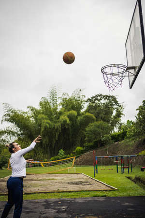 Vertical shot of a Hispanic woman with blonde hair playing basketballの写真素材