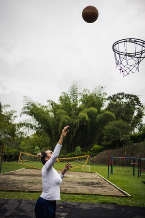 Vertical shot of a Hispanic woman with blonde hair playing basketballの写真素材