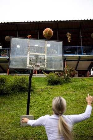 Vertical shot of a Hispanic woman with blonde hair playing basketballの写真素材