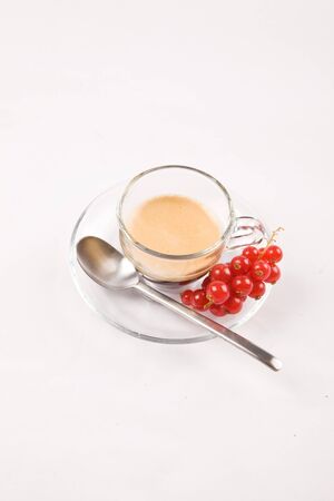 photo of espresso with currant in glass cup on white isolated backgroundの写真素材