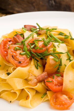 photo of delicious pasta with bacon and tomatoesの写真素材