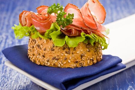 Delicious bacon and salad sandwich on blue cloth with parsleyの写真素材
