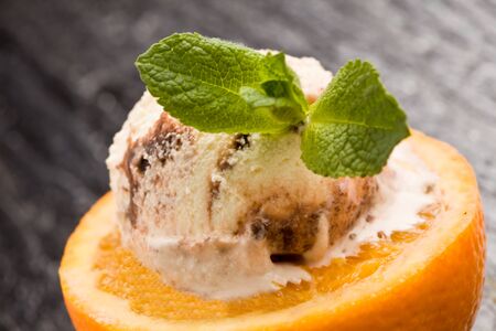 photo of cutted orange with ice cream and mint on itの写真素材