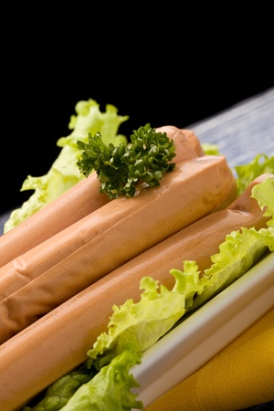 photo of delicious german sausages on green fresh lettuce with parsleyの写真素材