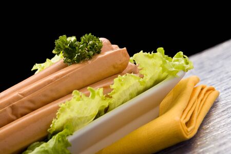photo of delicious german sausages on green fresh lettuce with parsleyの写真素材