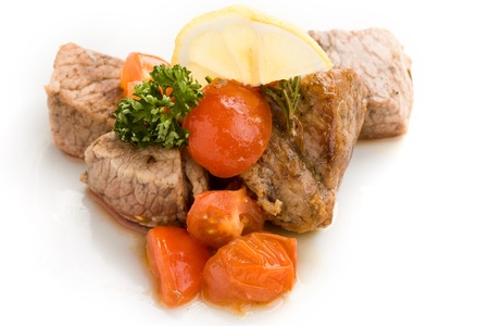 photo of delicious meat with fresh tomatoes lemon and parsleyの写真素材