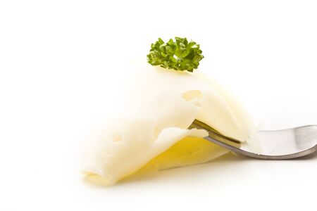 photo of fork with thin slice of cheese with parsleyの写真素材