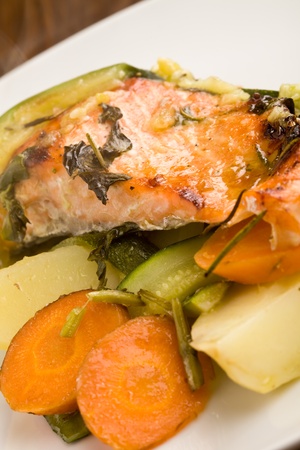 photo of baked salmon with vegetables on white plateの写真素材