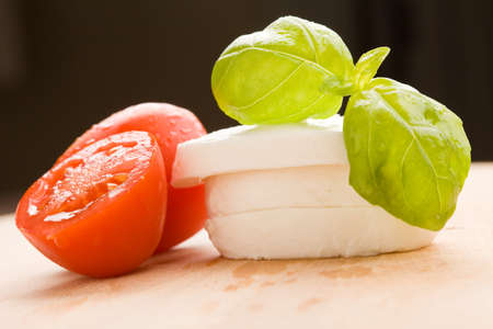 photo of tomatoe and mozzarella on wooden cutting boardの写真素材
