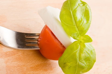 photo of fork with tomatoe and mozzarella on it の写真素材