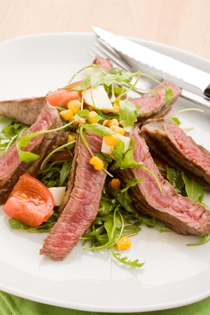 delicious slices of meat with rocket salad and toamtoes の写真素材
