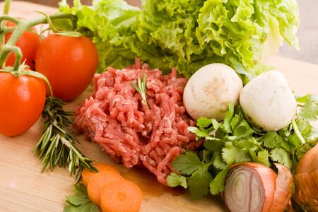 photo of minced meat with vegetables on a wooden chopping boardの写真素材