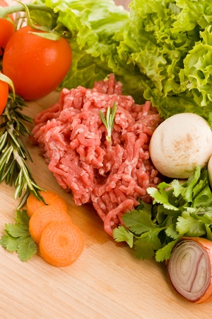 photo of minced meat with vegetables on a wooden chopping boardの写真素材