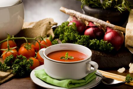 photo ofo delicious tomato soup with vegetables on wooden tableの写真素材