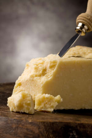 photo of delicious italian parmesan cheese with knife on wooden tableの写真素材