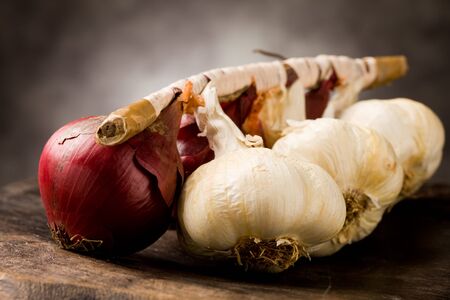 photo of onion and garlic on wooden table の写真素材