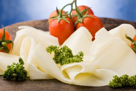 photo of delicious sliced cheese plate with tomatoes and parsleyの写真素材