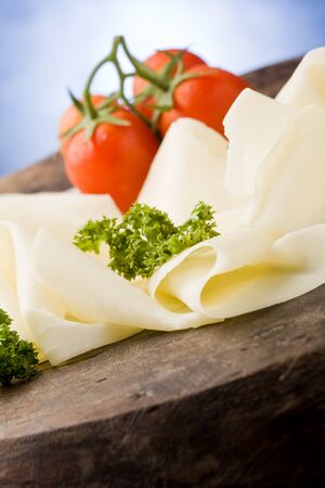 photo of delicious sliced cheese plate with tomatoes and parsleyの写真素材