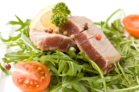photo of sliced Tuna Steak with arugula salad  on white isolated backgroundの写真素材