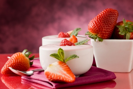 photo of delicious strawberry yogurt on red glass tableの写真素材