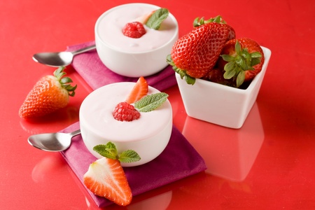 photo of delicious strawberry yogurt on red glass tableの写真素材