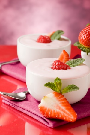 photo of delicious strawberry yogurt on red glass tableの写真素材
