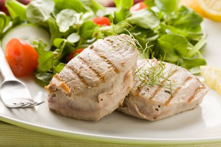 photo of grilled tuna steak with sald on green wooden tableの写真素材