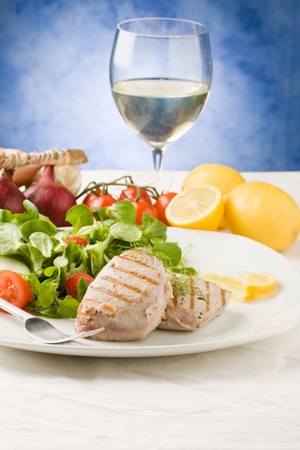 photo of grilled tuna steak with sald on green wooden tableの写真素材
