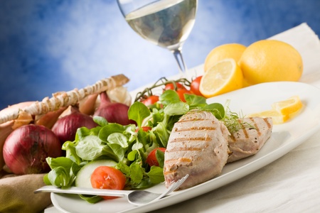 photo of grilled tuna steak with sald on green wooden tableの写真素材