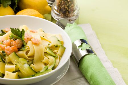 photo of delicious italian pasta with zucchini and shrimpsの写真素材