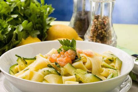 photo of delicious italian pasta with zucchini and shrimpsの写真素材
