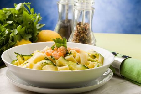 photo of delicious italian pasta with zucchini and shrimpsの写真素材