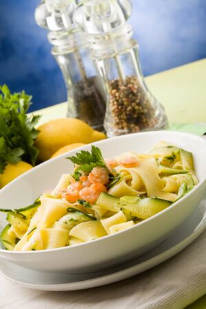 photo of delicious italian pasta with zucchini and shrimpsの写真素材